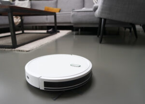 Image of a robot vacuum cleaner in the foreground of a modern home