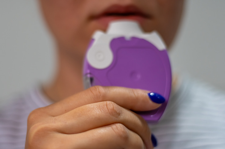 Woman holding medicine dry powder inhaler for asthma treatment or COPD